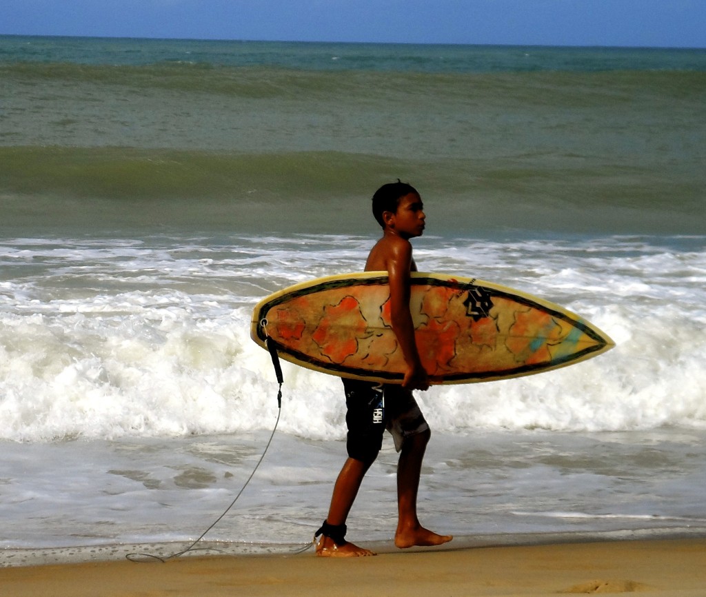 Brazilian boy with his surfboard.