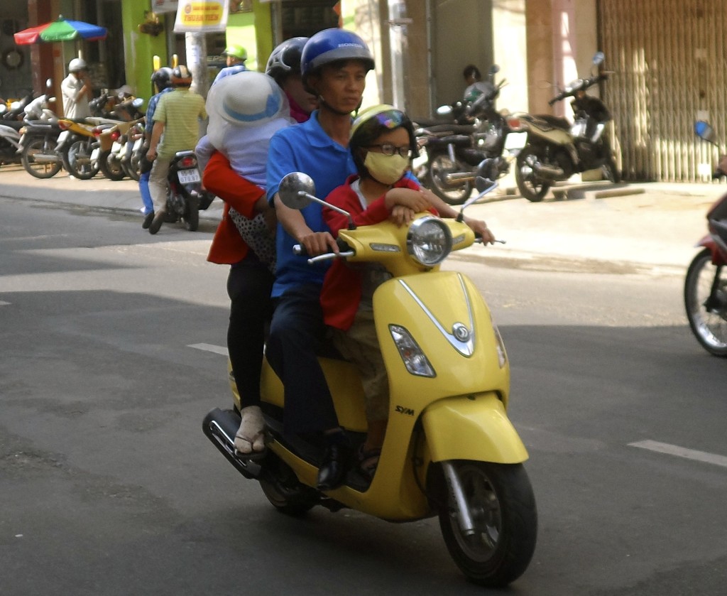 Family of 4 on a scooter in Vietnam.