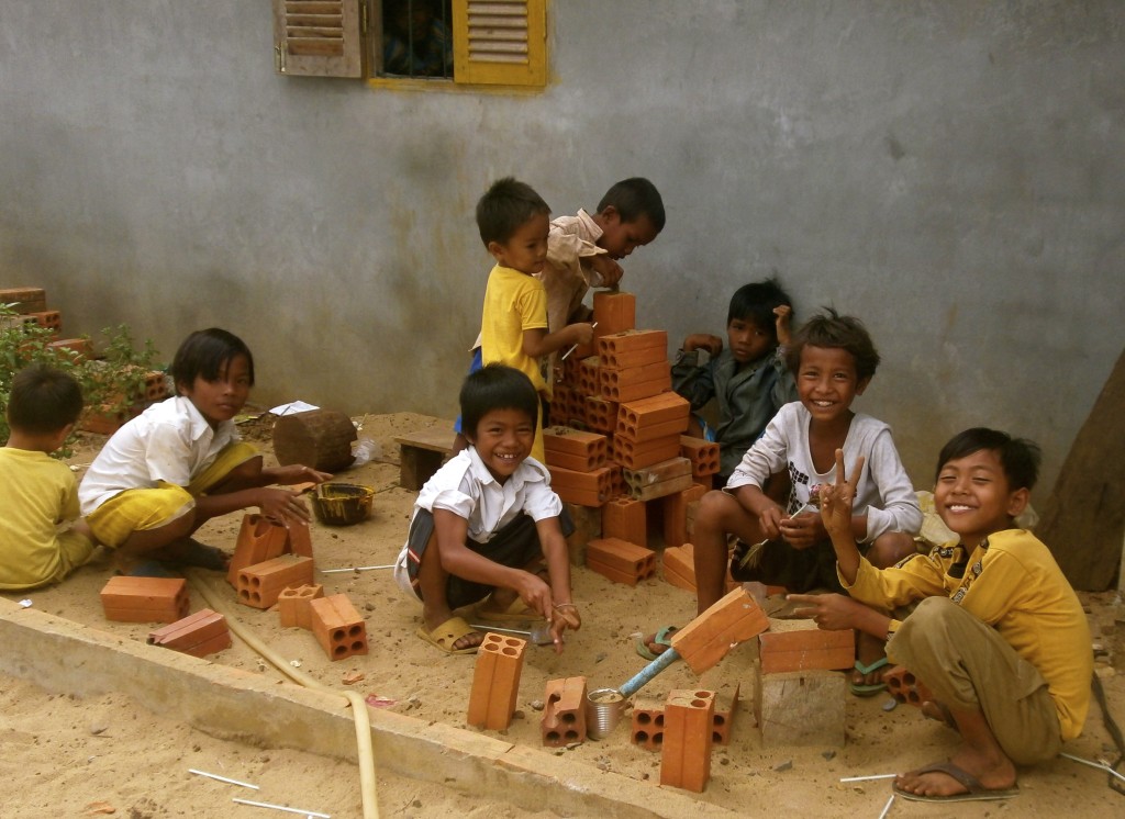 Happy cambodian school children and their simple toys.